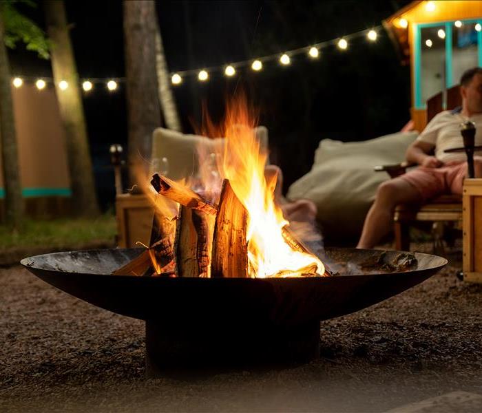 Cast iron fire pit campfire place at forest beach camping with brgiht burning flame at evening time